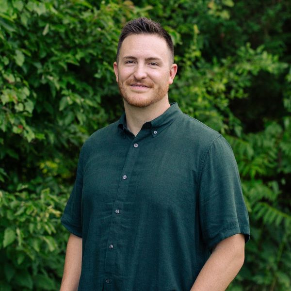Young Woman Smiling By Green Wall